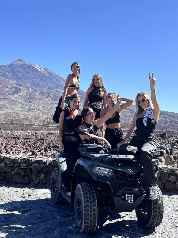 Rider standing next to double quad bike on volcanic road stop